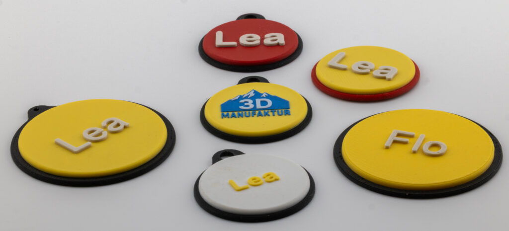 Mehrfarbige 3D‑gedruckte Anhänger, Magnetschilder und Werbeartikel aus Kleinserie.